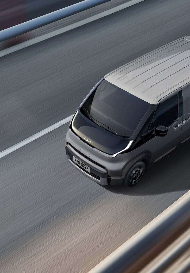 Draufsicht auf den Kia PV5 Passenger bei der Fahrt auf der Autobahn.